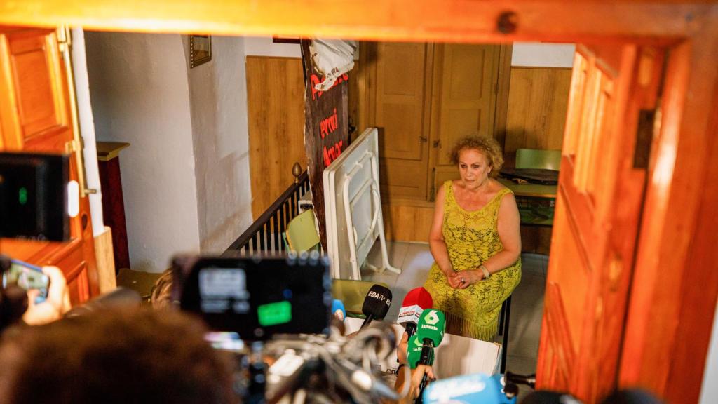 Periodistas hablando con la madre de Rubiales al otro lado de una puerta