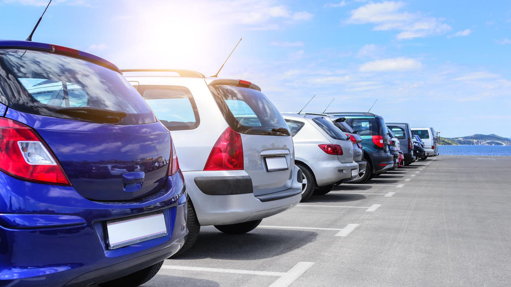 Imagen de archivo de coches aparcados en un parking frente al mar.