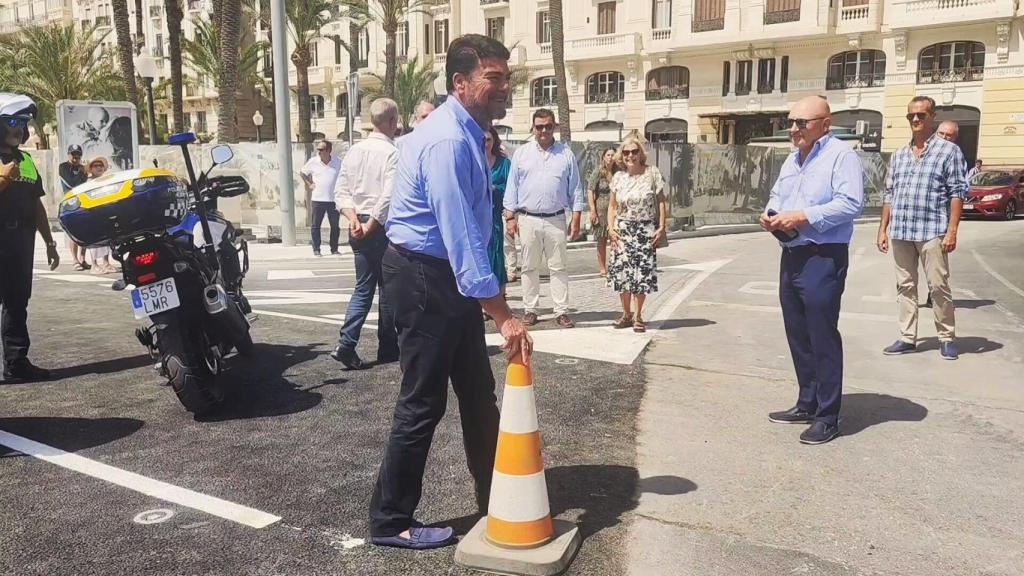 El alcalde Luis Barcala retira los conos que impedían el paso del tráfico en el frente litoral.