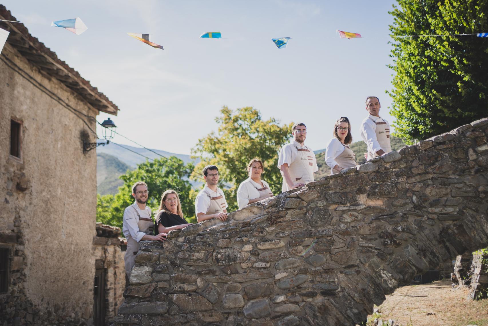 El equipo de cocina de Antonio Pérez (i) y Pilar Juanes (2i) posa en las escaleras que conducen a la iglesia de Zaldierna, frente al restaurante