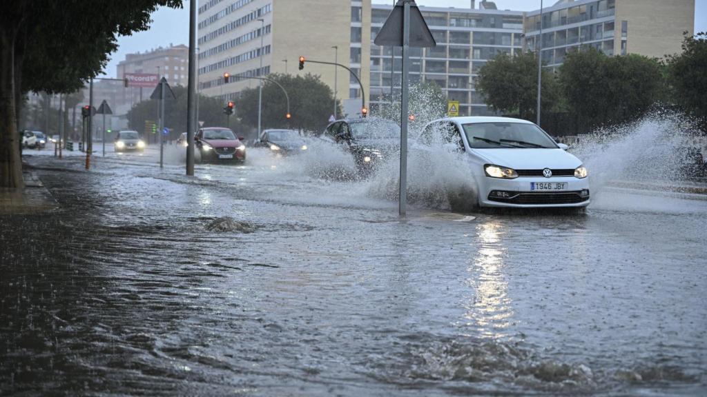 Varios vehículos transitan por la avenida Casalduch parcialmente inundada este sábado en Castellón de la Plana.