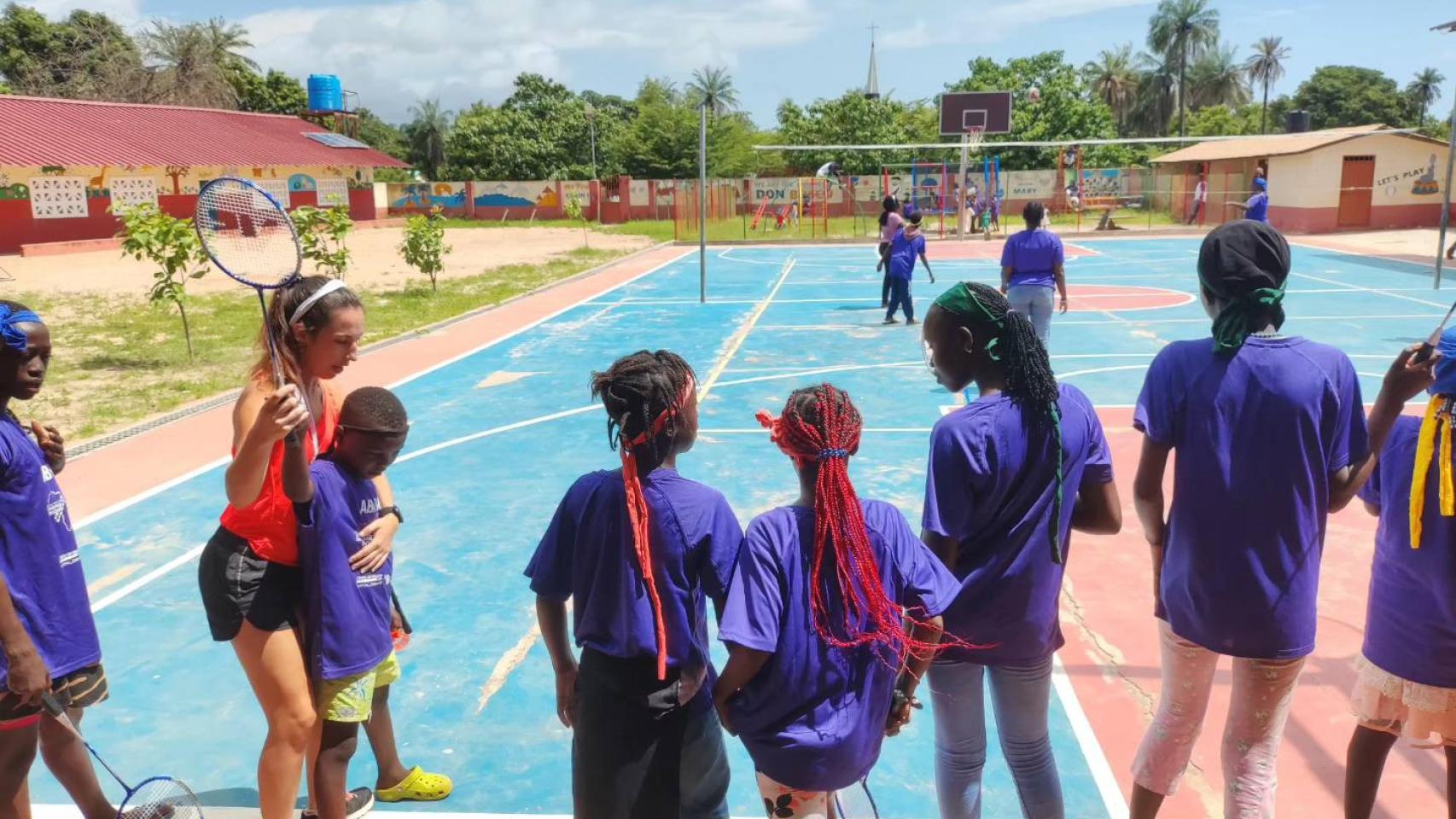 Ana Sanz muestra a un niño de Gambia cómo coger la raqueta de bádminton