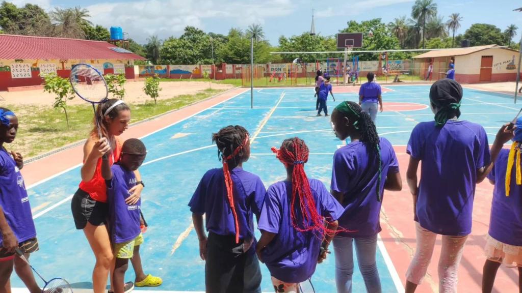 Ana Sanz muestra a un niño de Gambia cómo coger la raqueta de bádminton