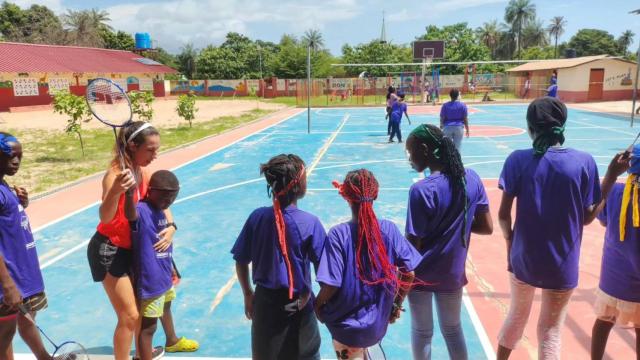 Ana Sanz muestra a un niño de Gambia cómo coger la raqueta de bádminton