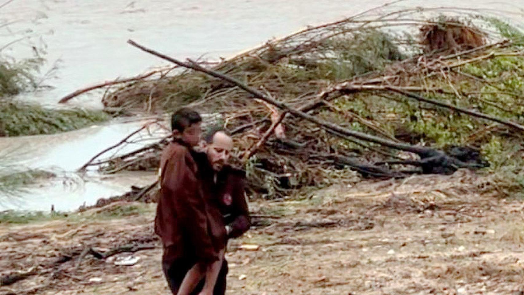 Eduardo Cañadas, un guarda de Aldea del Fresno, con el pequeño Izan en brazos durante el rescate este lunes.