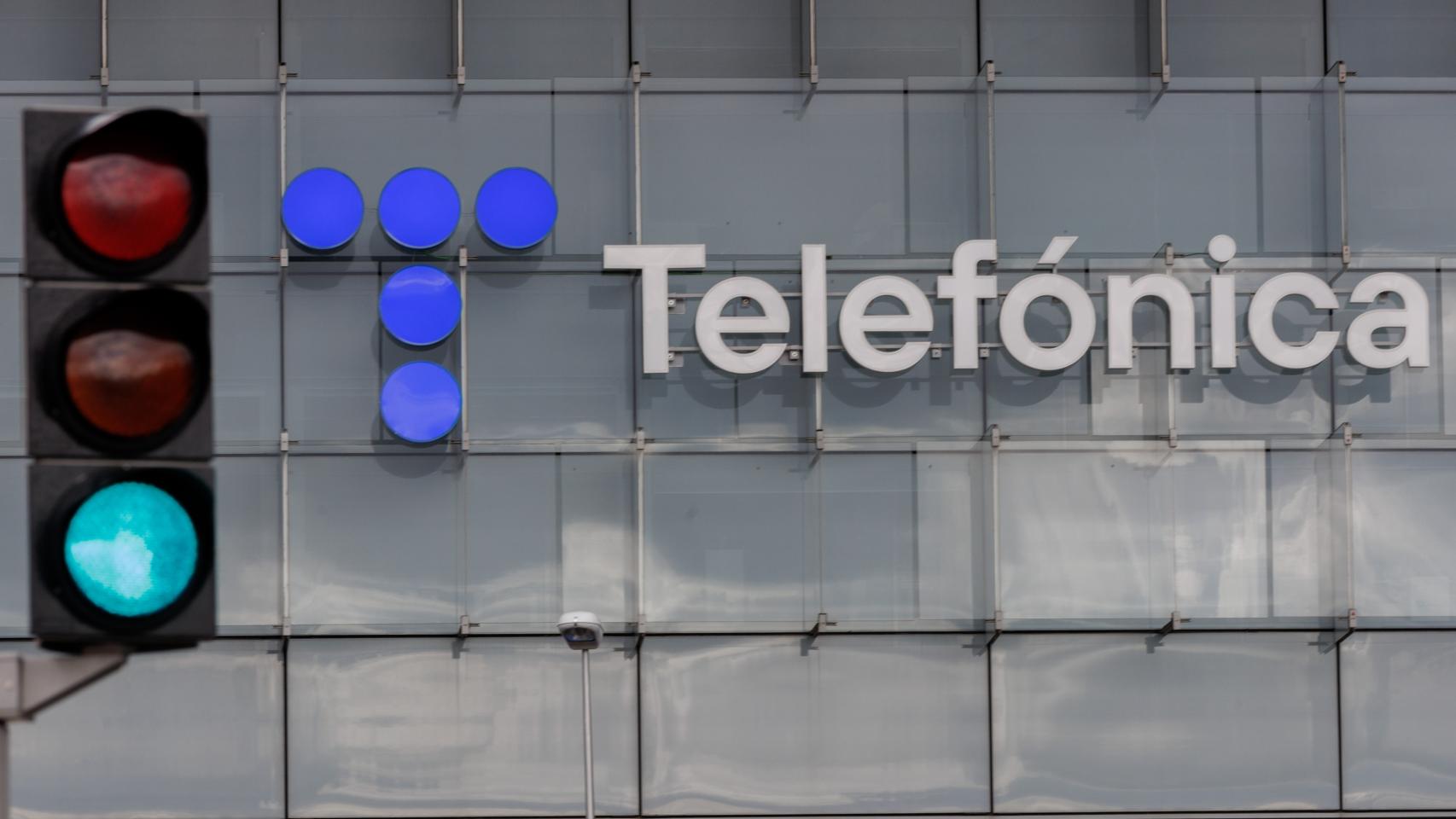 Un semáforo en verde frente a la fachada de la sede de Telefónica, a 6 de marzo de 2023, en Madrid (España).