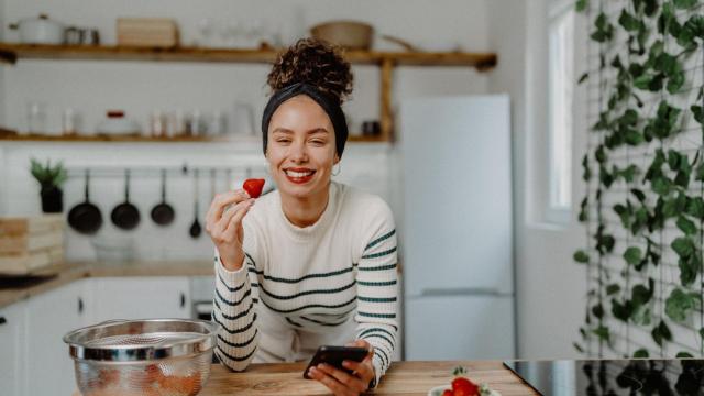 Una mujer, comiendo una fresa.
