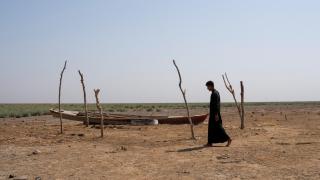 Un hombre camina por las marismas secas de Chebayesh, en Dhi Qarç (Irak). Tuvo que migrar a causa de las sequías.