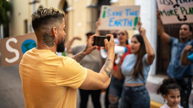Un hombre grabando una manifestación en la calle.