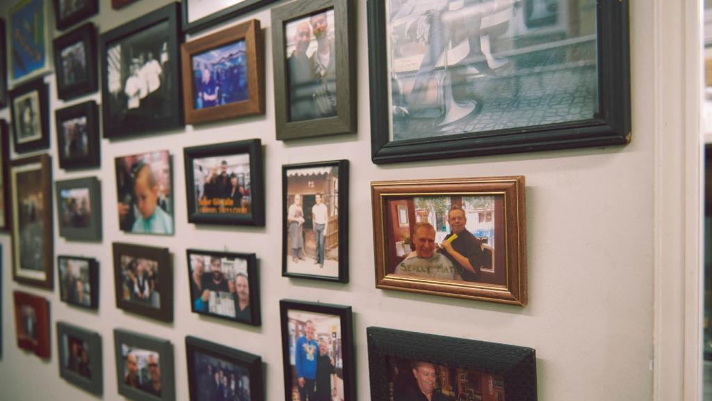 Marcos con fotografías de clientes habituales de la barbería.