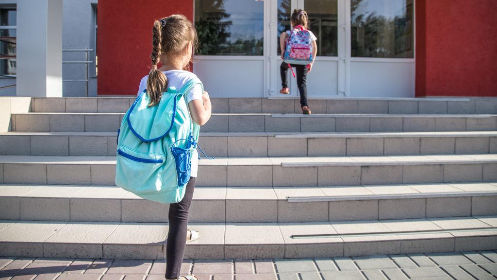 Dos niñas entran a un centro escolar.
