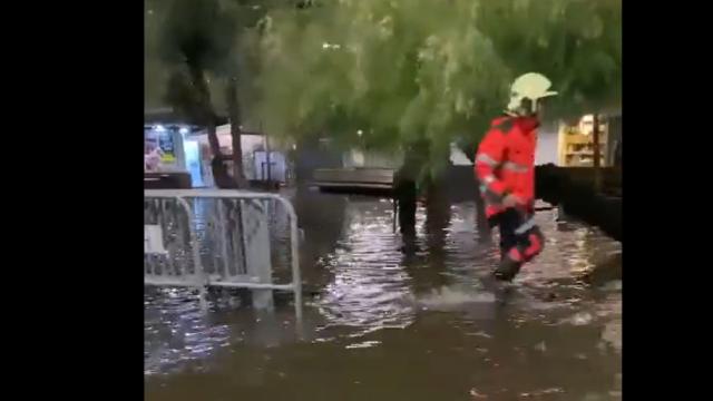 Un bombero trabaja para tratar de drenar el agua en la carretera