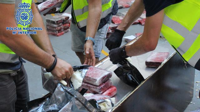 Los agentes extraen los 'ladrillos' de cocaína de uno de los muebles.