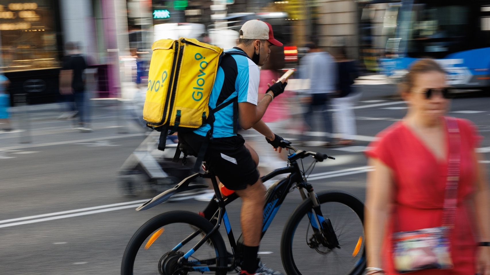 Un repartidor de Glovo en bicicleta por una calle del centro de Madrid.