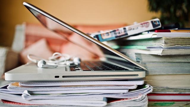 Imagen de un ordenador portátil sobre una pila de libros.