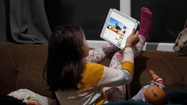 Una niña juega con su tablet.