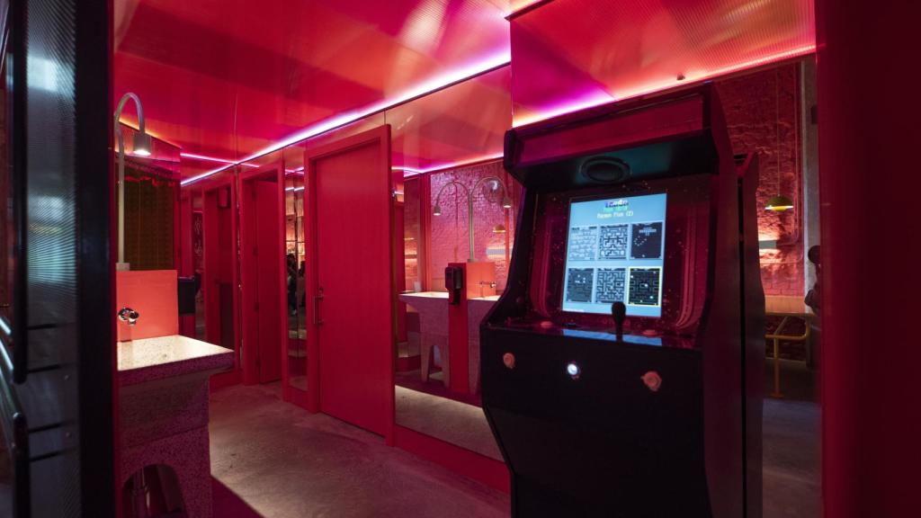 Baños con una máquina de arcade.