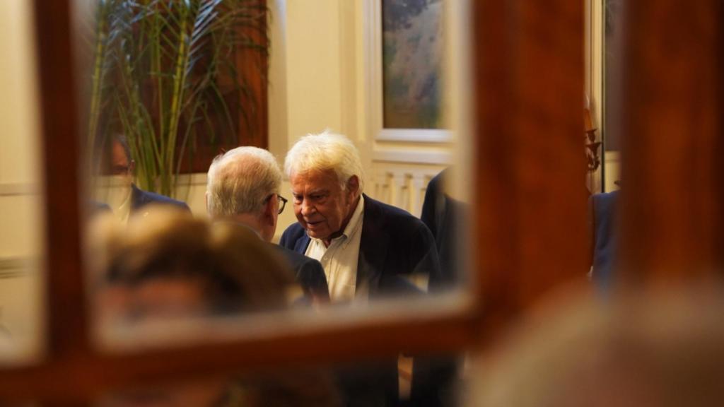 Felipe González, anoche, habla en un aparte con Alfonso Guerra, en el Ateneo de Madrid, antes de subir ambos a la tarima.