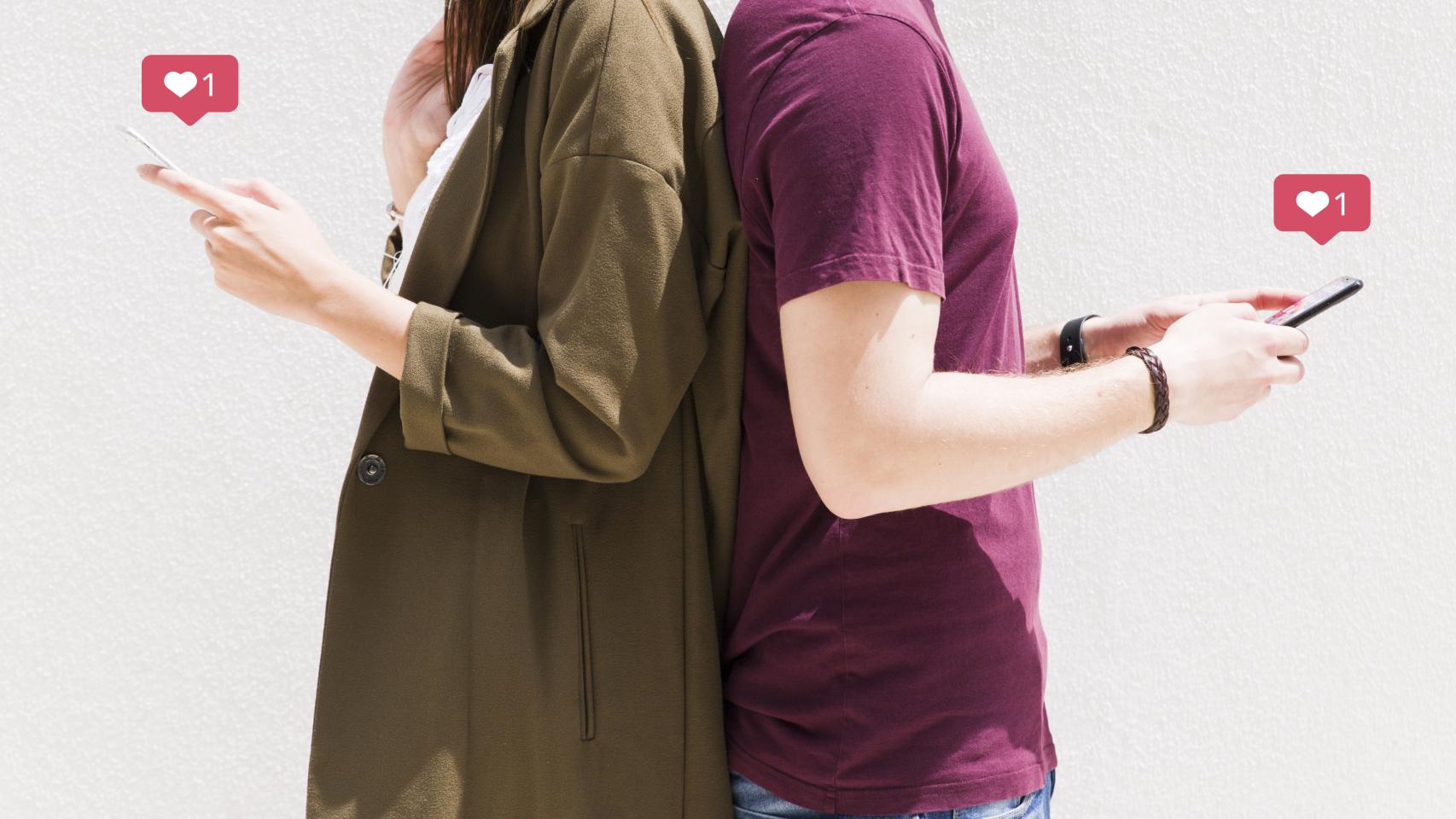 Una pareja de espalda con móviles en la mano.
