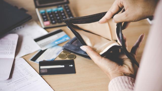Mano de mujer abriendo un monedero vacío (iStock)