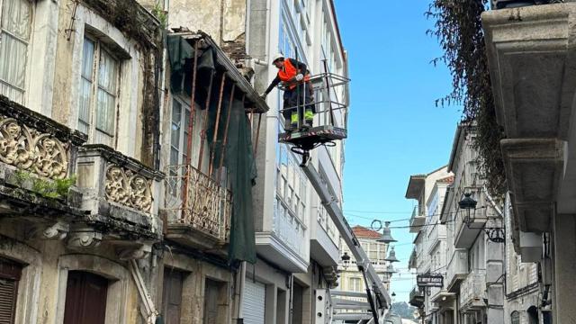 Operarios retiran elementos que suponían un peligro en un edificio en ruinas de la calle Travesa.