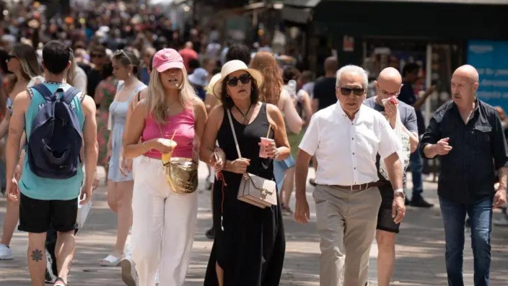 Varias personas paseando por Barcelona.