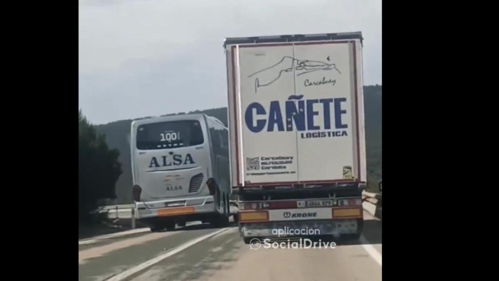 Un autocar adelanta a un camión en línea continua y en plena curva