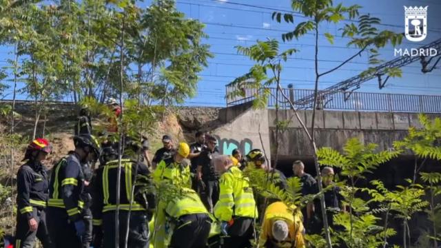 Agentes de Bomberos y Samur-PC atendiendo al herido en el terraplén.