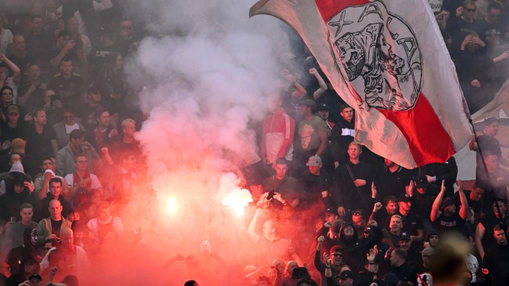 Los aficionados del Ajax lanzan bengalas al terreno de juego