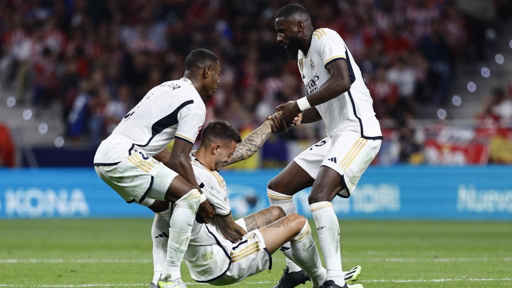 Militao y Rüdiger ayudan a Joselu a levantarse.