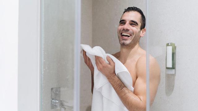 Un hombre secándose con una toalla tras la ducha.