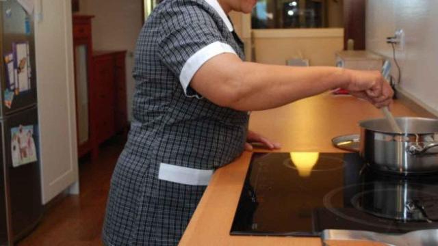 Empleada del hogar cocinando.