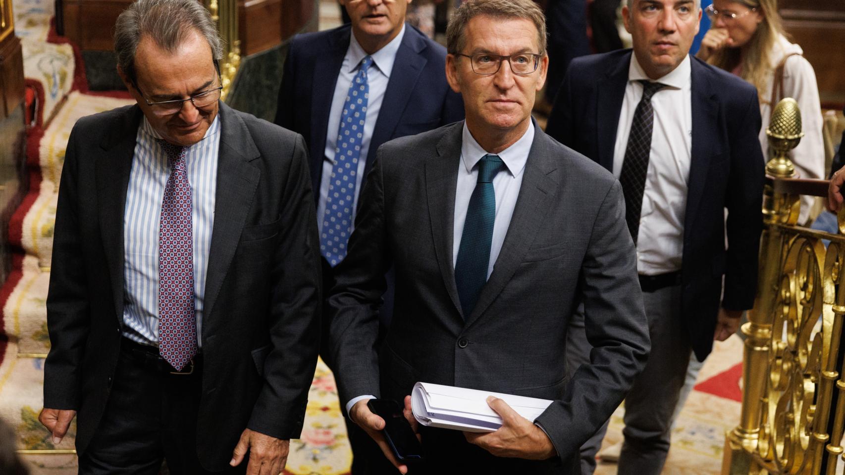 El presidente del PP, Alberto Núñez Feijóo (d), sale de una sesión plenaria en el Congreso de los Diputados.