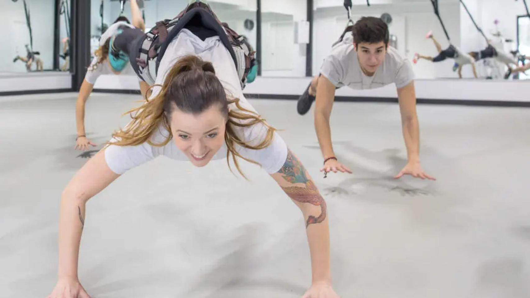 Una pareja en el gimnasio realizando 'Bungee Fitness'.