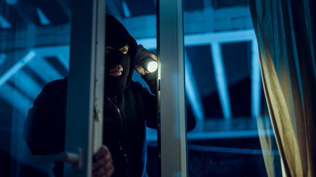Un ladrón entrando en un domicilio.