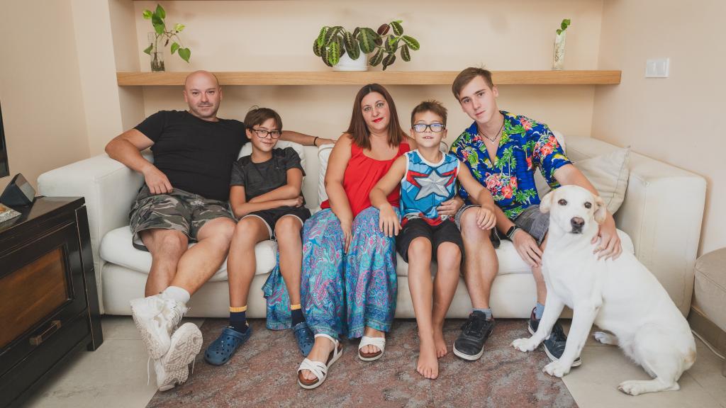 Javier, Ares, Sandra, Naím, Airam y la perra Cali, en el salón de su casa.