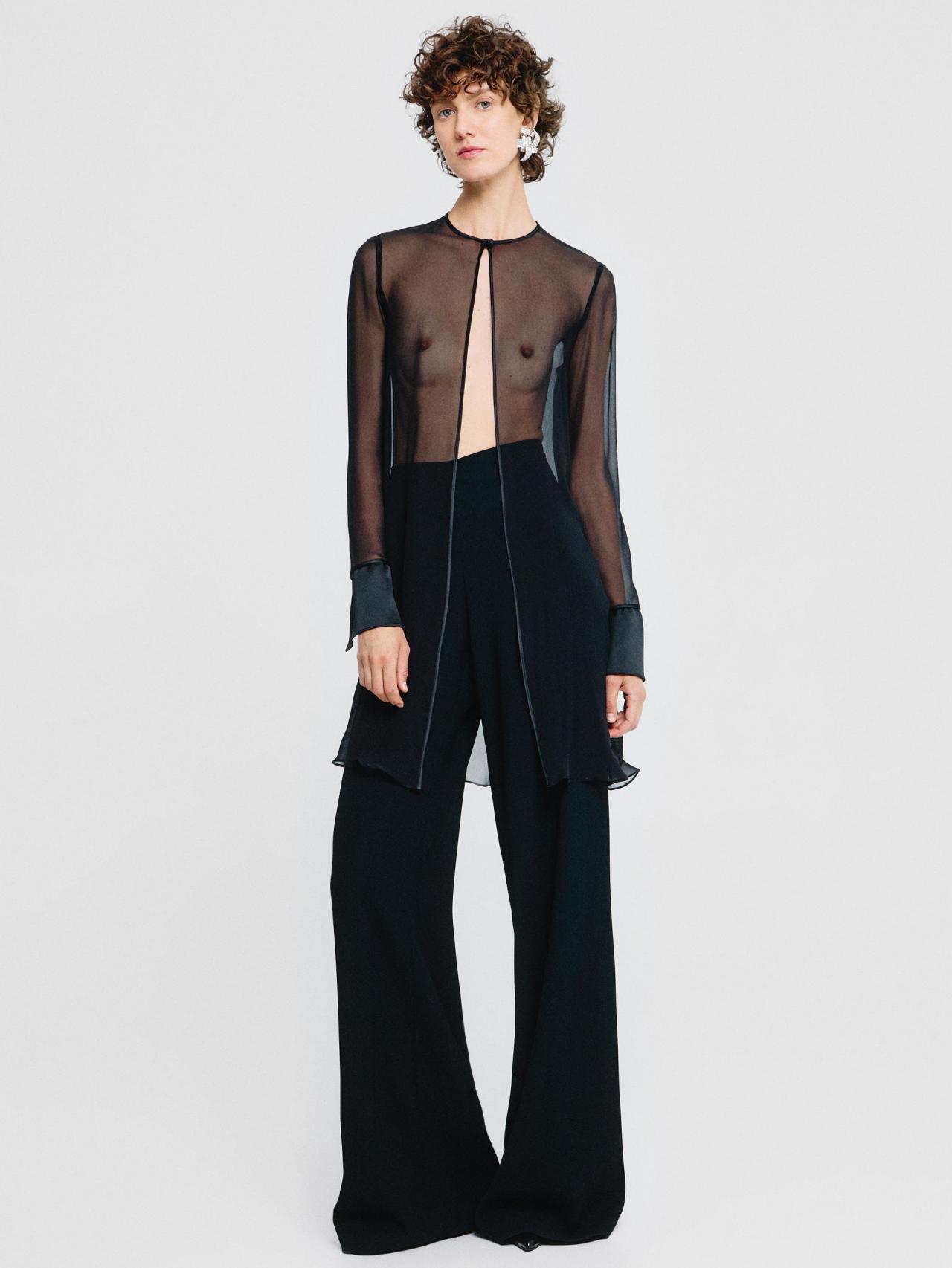 Blusa negra de gasa transparente.