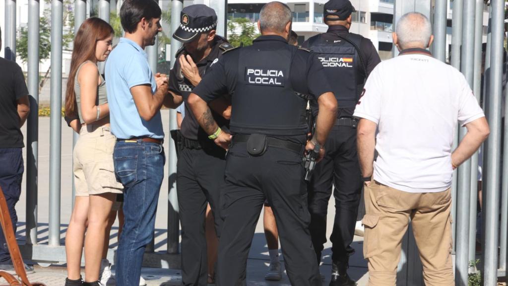 Agentes de la Policía Local y Nacional, en la puerta del centro educativo durante el desalojo.