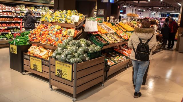Varios consumidores comprando en un supermercado.