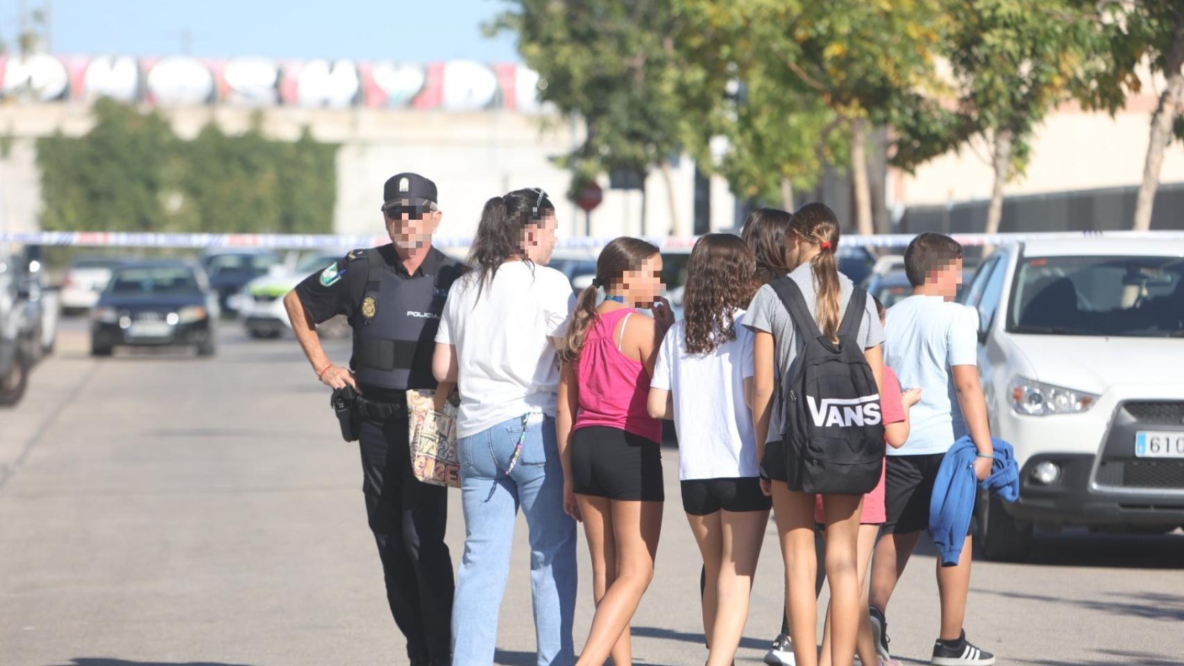 Imagen de archivo de alumnos entrando en un instituto en presencia de un agente de Policía.