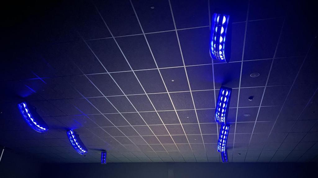Los altavoces del techo de la sala iluminados en color azul.