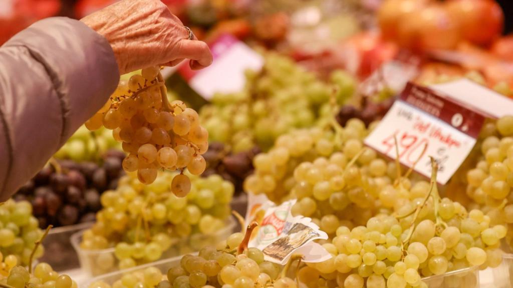 Imagen de archivo de una persona cogiendo uvas.