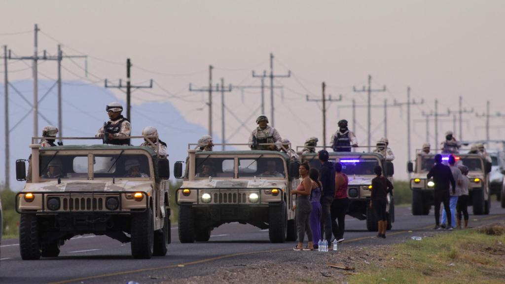 Coches del ejército mexicano junto a los migrantes que esperan a cruzar a EEUU