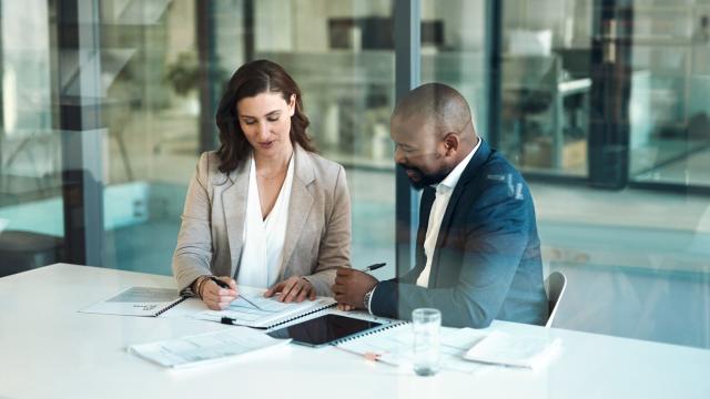 Imagen de archivo de dos personas firmando documentos. Foto: iStock.