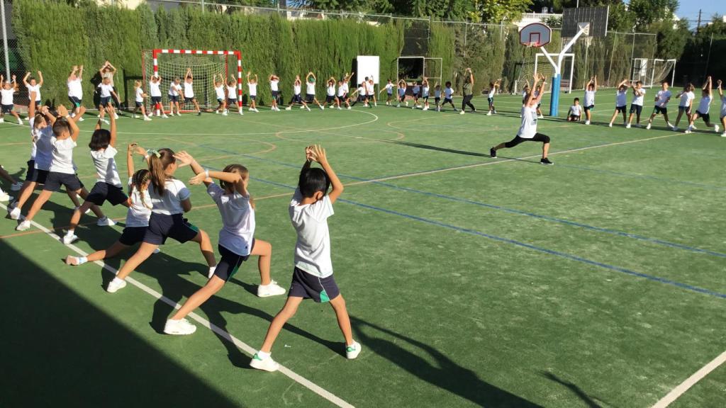 Algunos alumnos practicando yoga en el patio.