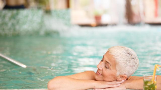 Una mujer disfruta de un baño en la piscina.