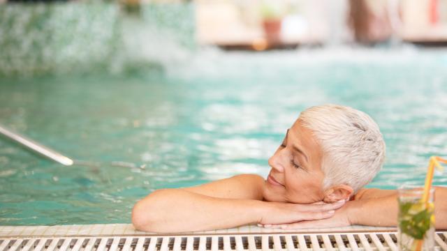 Una mujer disfruta de un baño en la piscina.