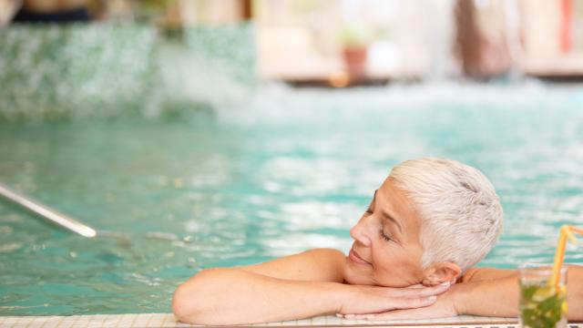 Una mujer disfruta de un baño en la piscina.