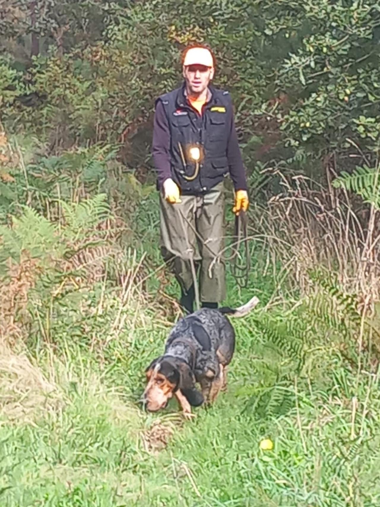Un cazador con su perro, siguiendo la técnica de la traílla