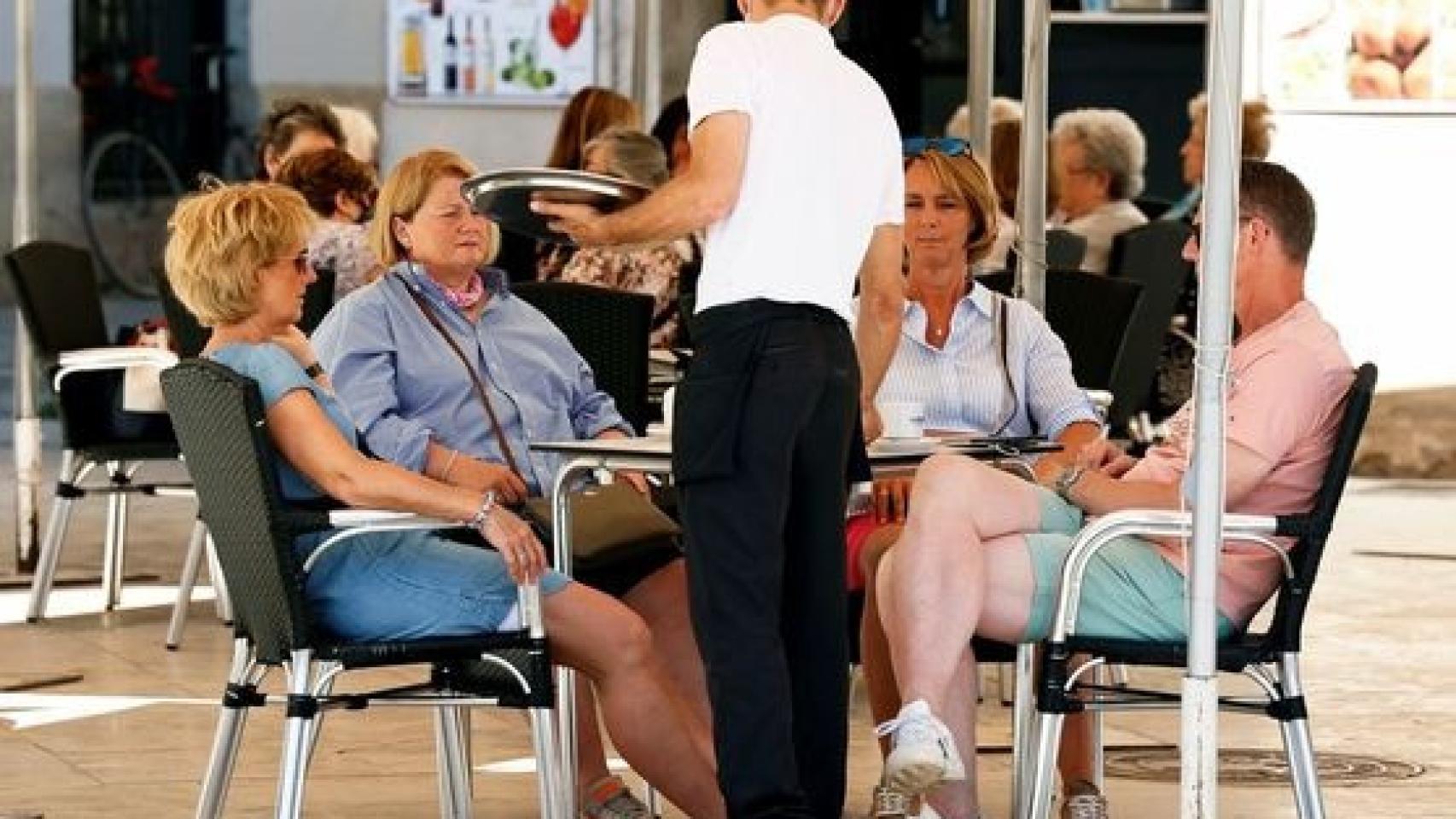 Imagen de archivo de un camarero atendiendo a los clientes de un bar.